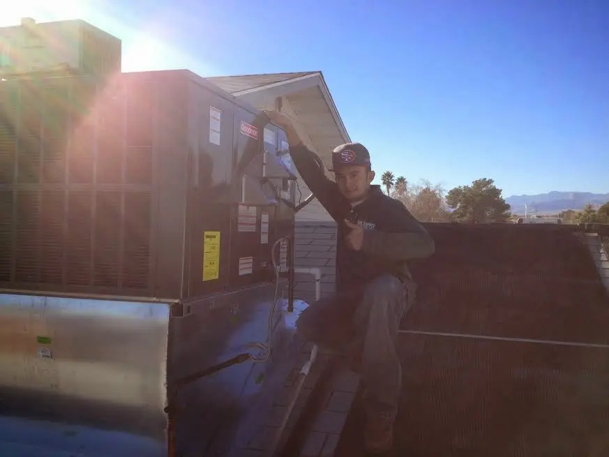 HVAC technician performing Air Duct Repair on a rooftop unit in Coolbaugh